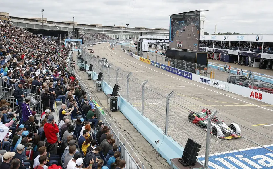 Formula E racing past a full grandstand