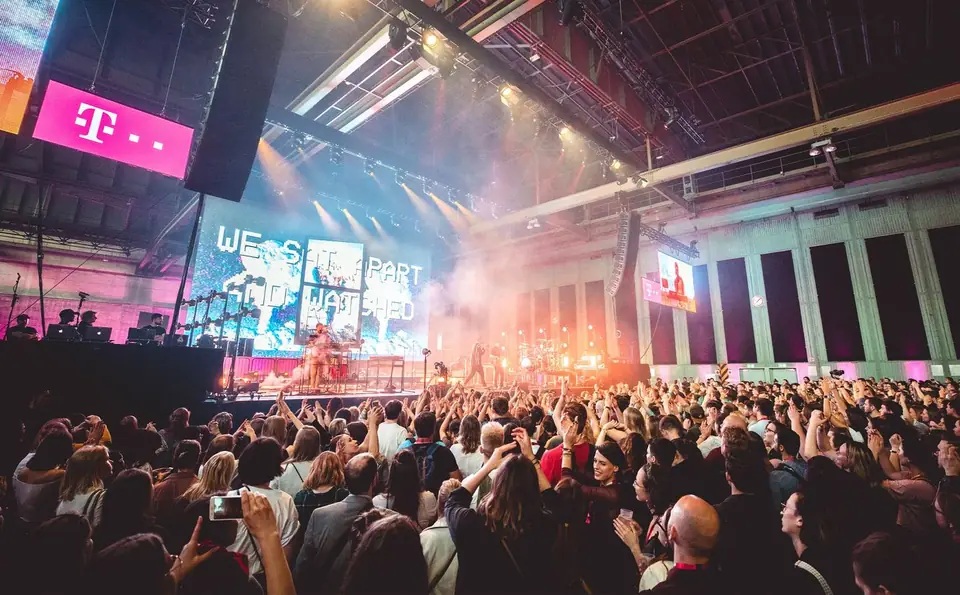 A crowd in front of the concert stage in the hangar