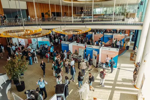 Visitors moving between exhibition stands in the Messe Berlin atrium, GREENTECH FESTIVAL 2024