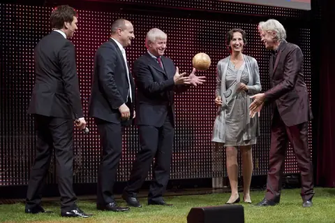 An award being handed over on stage at the GREEN AWARDS, 2025