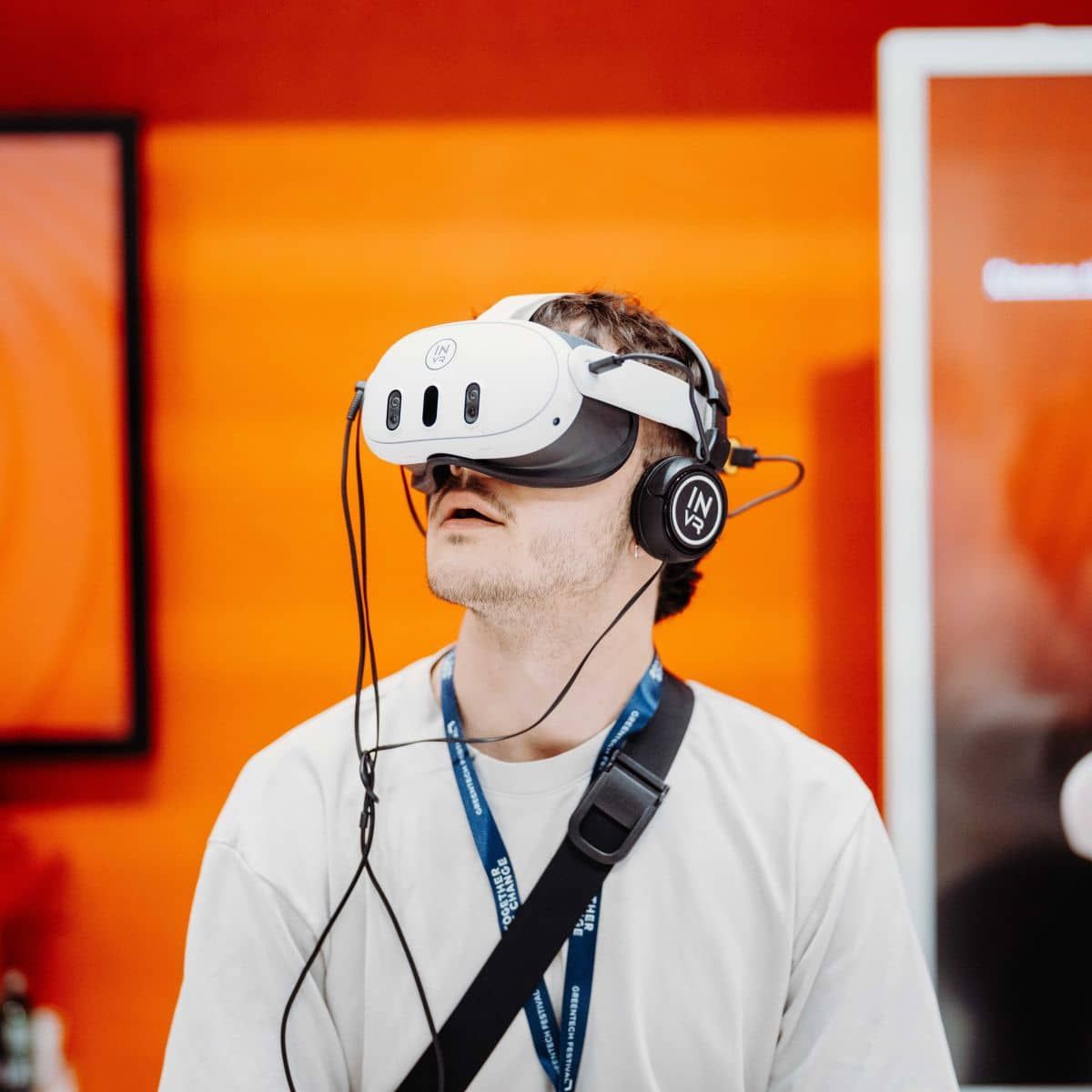 A visitor trying a VR exhibit at GREENTECH FESTIVAL, wearing a festival lanyard